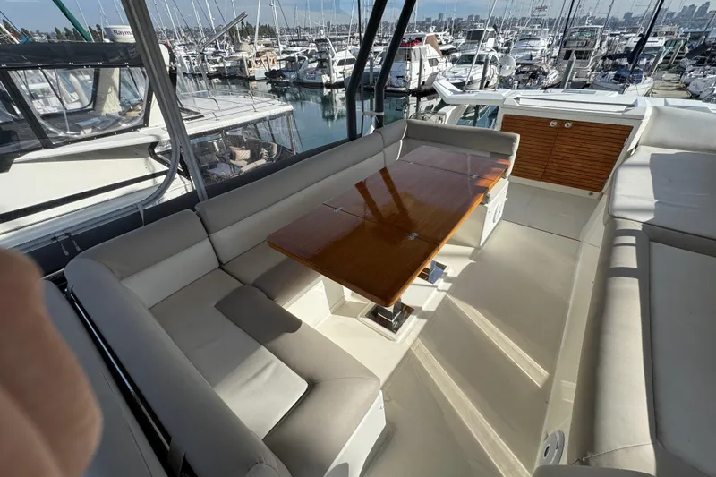 Slide: The Image of Luxurious seating area on a 2020 Beneteau Monte Carlo 52 yacht, docked at a marina. - 47