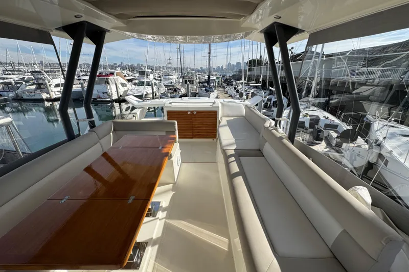 Slide: The Image of Luxurious 2020 Beneteau Monte Carlo 52 yacht interior with elegant seating and marina view. - 48