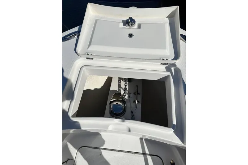 Slide: The Image of 2015 Regulator 28 Forward Seating boat anchor compartment open, showing chain and mechanism. - 19