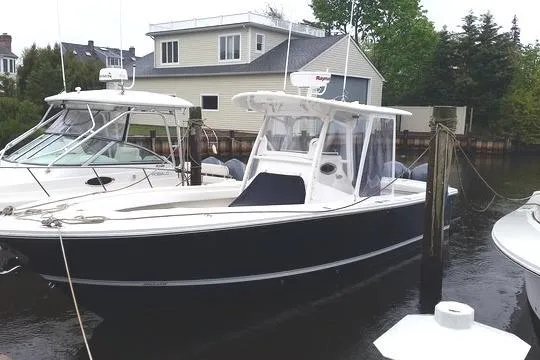 Slide: The Image of 2015 Regulator 28 Forward Seating boat docked near waterfront homes. - 2