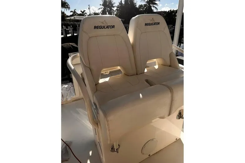 Slide: The Image of 2015 Regulator 28 Forward Seating boat with dual beige seats and logo. - 24