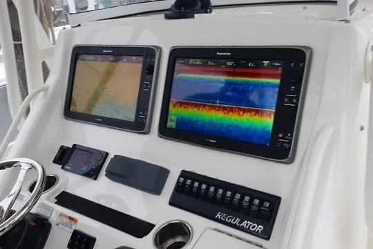 Slide: The Image of Control panel of a 2015 Regulator 28 Forward Seating boat with navigation screens. - 29