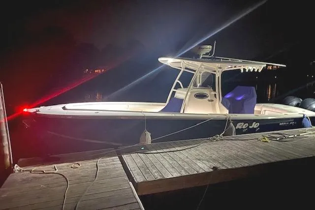 Slide: The Image of 2015 Regulator 28 Forward Seating boat docked at night with lights on. - 4