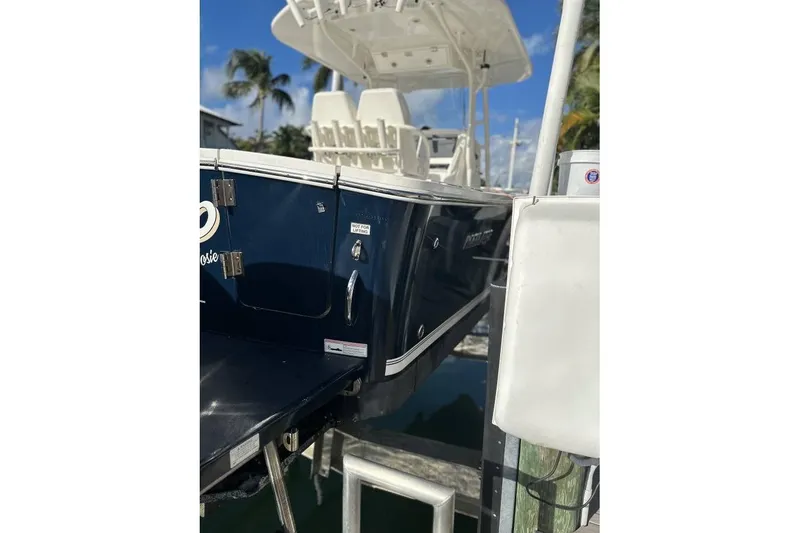 Slide: The Image of 2015 Regulator 28 Forward Seating boat docked, featuring sleek design and white seating. - 6