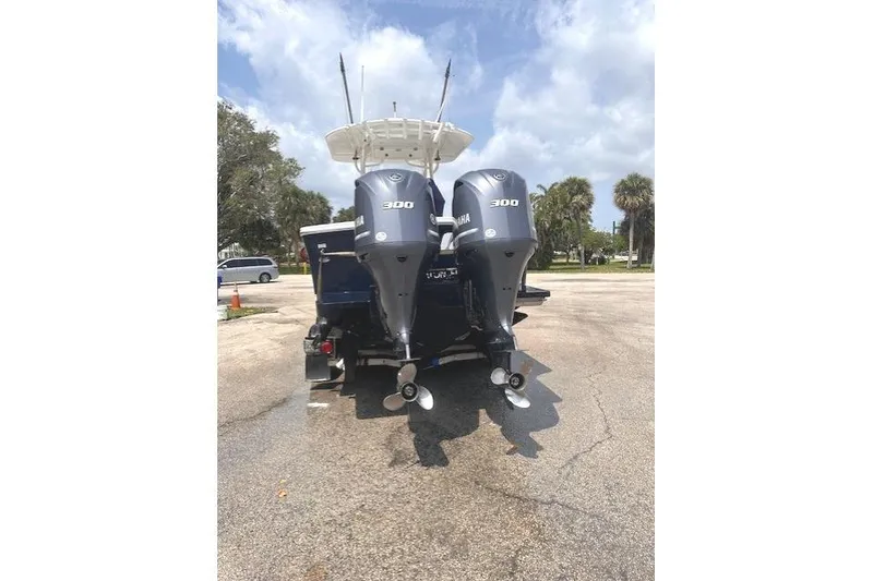 Slide: The Image of 2015 Regulator 28 Forward Seating boat with twin Yamaha 300 engines, parked outdoors. - 9