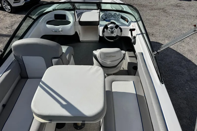 Slide: The Image of 2017 Caravelle 19 EBo Bowrider interior with seating and steering wheel, parked on gravel. - 7
