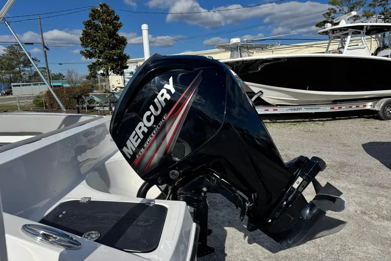 Slide: The Image of 2017 Caravelle 19 EBo Bowrider with Mercury outboard motor, parked outdoors. - 8