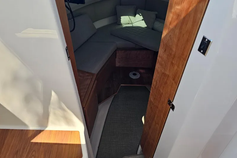 Slide: The Image of 2026 Cutwater C-288 Coupe cabin interior with wooden door and cozy seating area. - 11