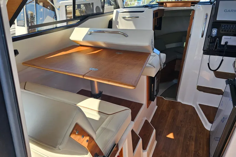 Slide: The Image of 2026 Cutwater C-288 Coupe interior with dining area and navigation equipment. - 8