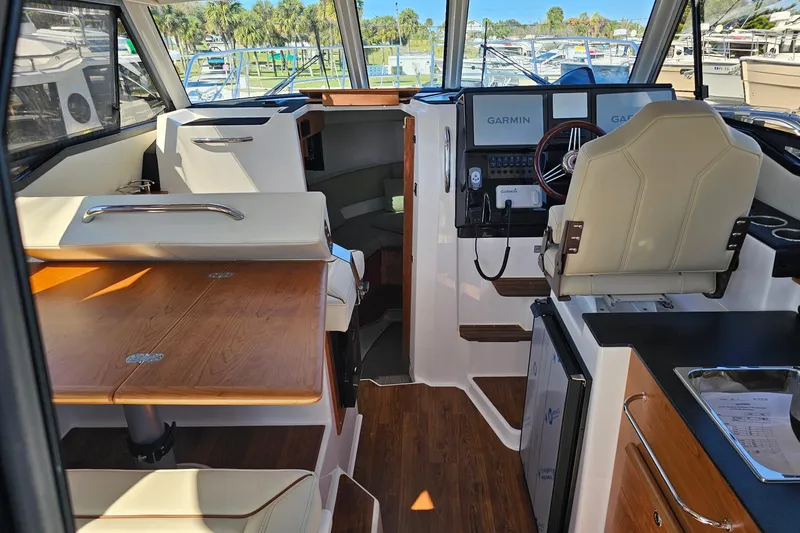 Slide: The Image of Interior of 2026 Cutwater C-288 Coupe, featuring helm, seating, and wooden table. - 9