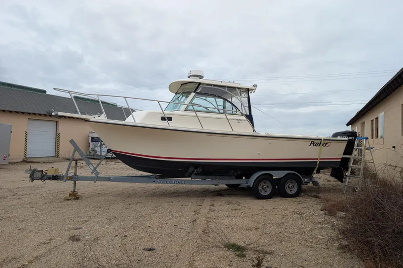 The Image of 2008 Parker 2510 XL Walkaround boat on trailer, parked outdoors near buildings. - 0