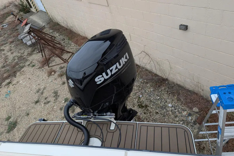 Slide: The Image of 2008 Parker 2510 XL Walkaround with Suzuki outboard motor, docked near a building. - 12