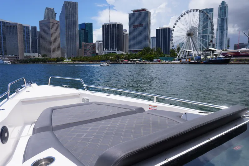 Slide: The Image of 2020 Axopar 37 XC Cross Cabin boat with city skyline and Ferris wheel in background. - 12