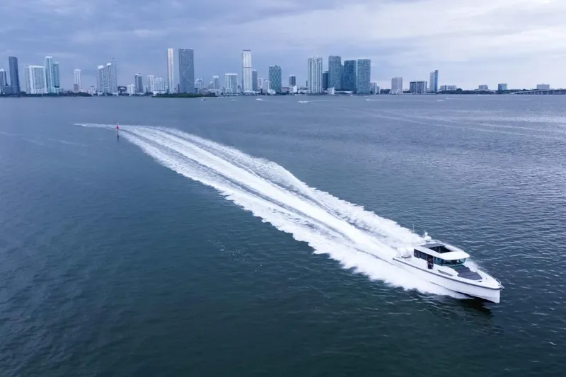 Slide: The Image of Axopar 37 XC Cross Cabin 2020 cruising on water with city skyline backdrop. - 22