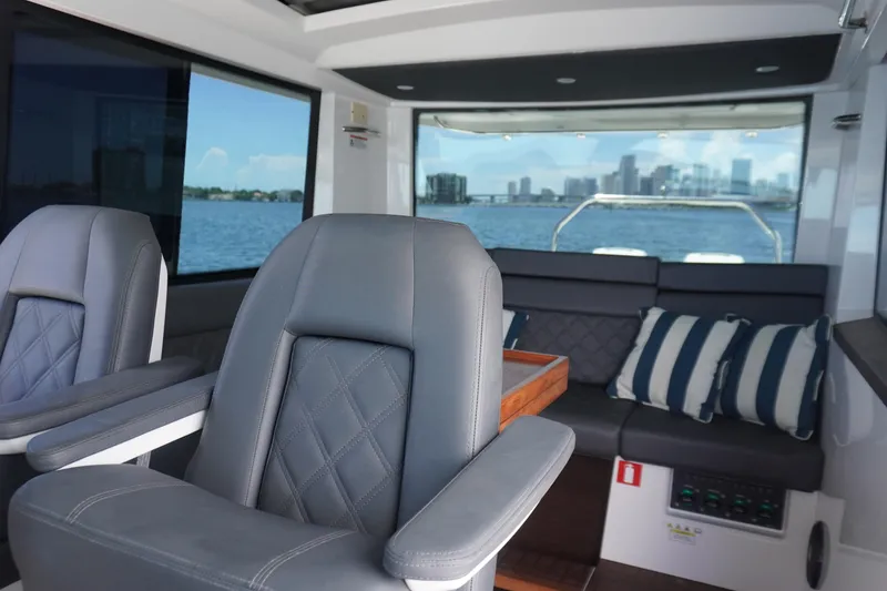 Slide: The Image of 2020 Axopar 37 XC Cross Cabin interior with leather seats and waterfront view. - 5