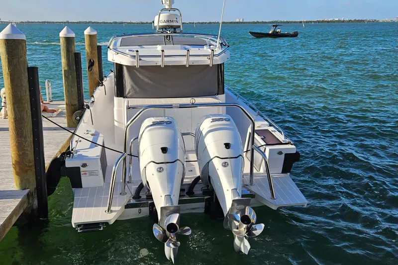 Slide: The Image of 2020 Axopar 37 XC Cross Cabin with twin outboard engines docked by the sea. - 8
