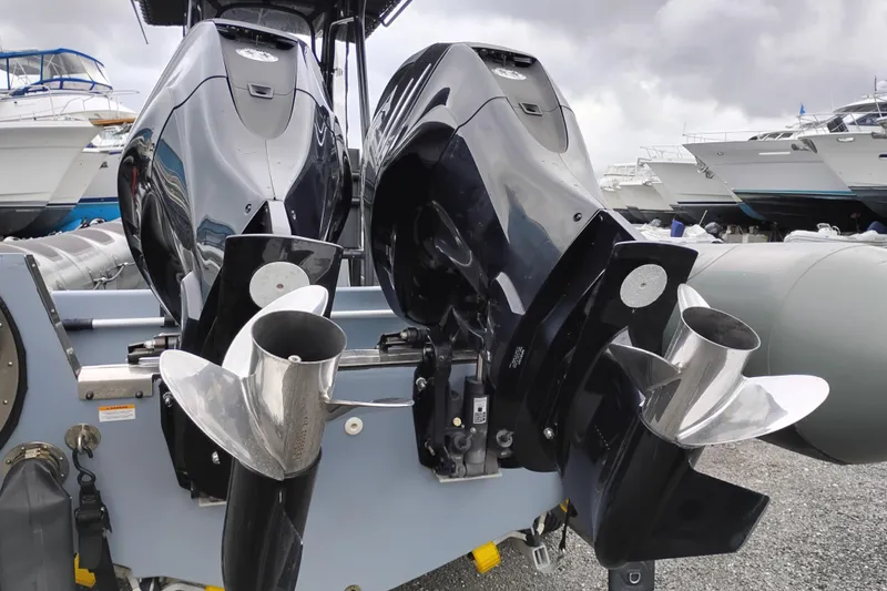 Slide: The Image of Twin outboard motors on a 2008 Valiant PT-750 boat, docked with other vessels. - 3