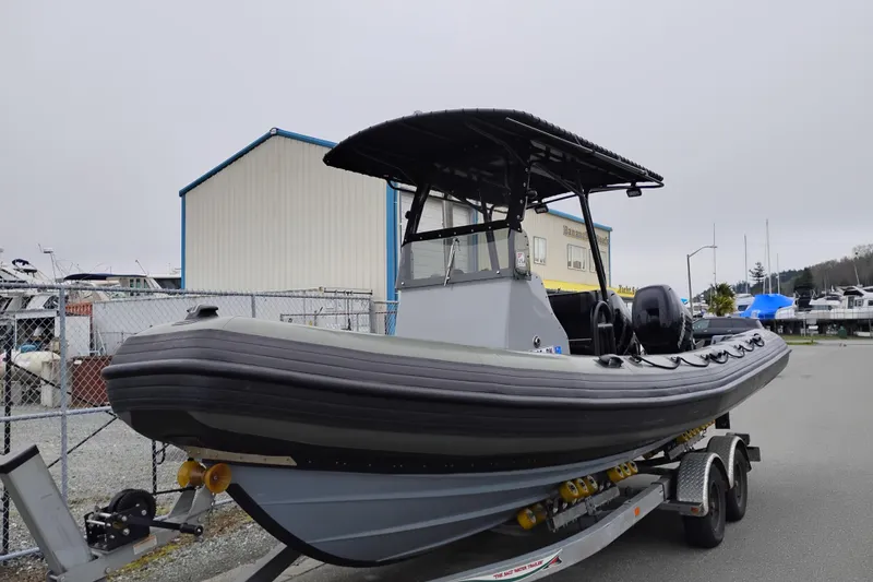 Slide: The Image of 2008 Valiant PT-750 boat on trailer, parked near marina buildings. - 6