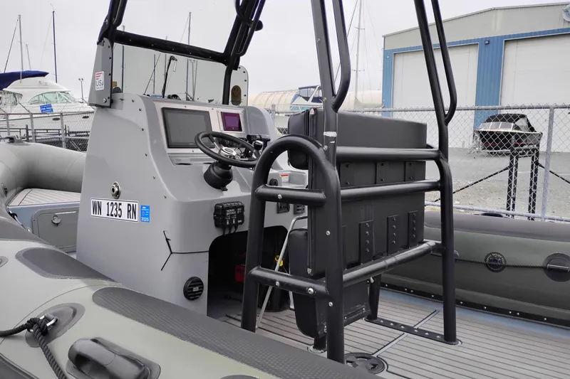 Slide: The Image of 2008 Valiant PT-750 boat interior with steering console and seating, docked near blue warehouse. - 9