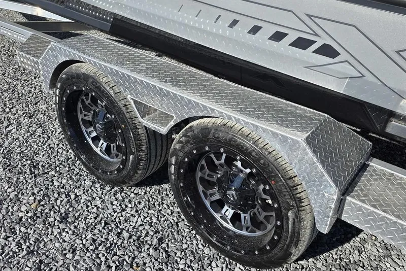 Slide: The Image of 2026 Xpress H24B Bay trailer with dual black alloy wheels on gravel. - 23