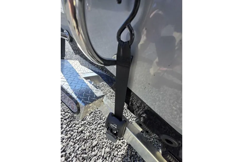Slide: The Image of Secure strap on 2026 Xpress H24B Bay boat trailer with diamond plate step. - 4