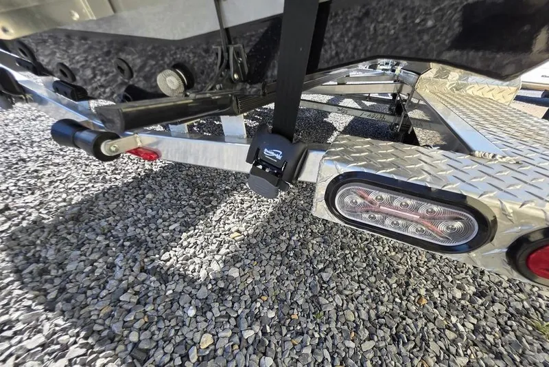 Slide: The Image of Trailer hitch and tail light of 2026 Xpress H24B Bay boat on gravel. - 9