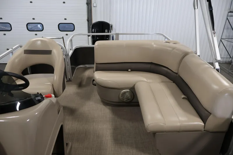 Slide: The Image of 2023 Sun Tracker Party Barge 18 DLX interior with beige seating and steering console. - 29