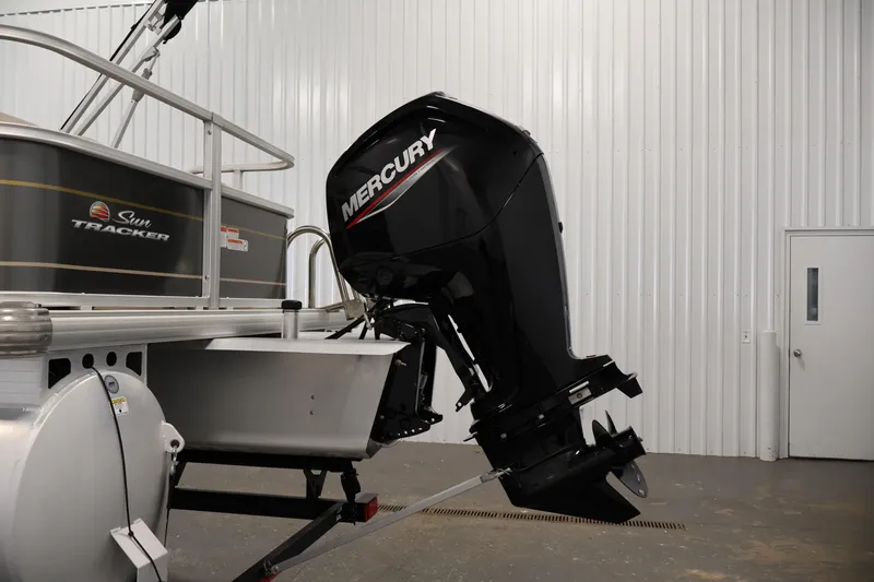 Slide: The Image of 2023 Sun Tracker Party Barge 18 DLX with Mercury outboard motor in a garage. - 35