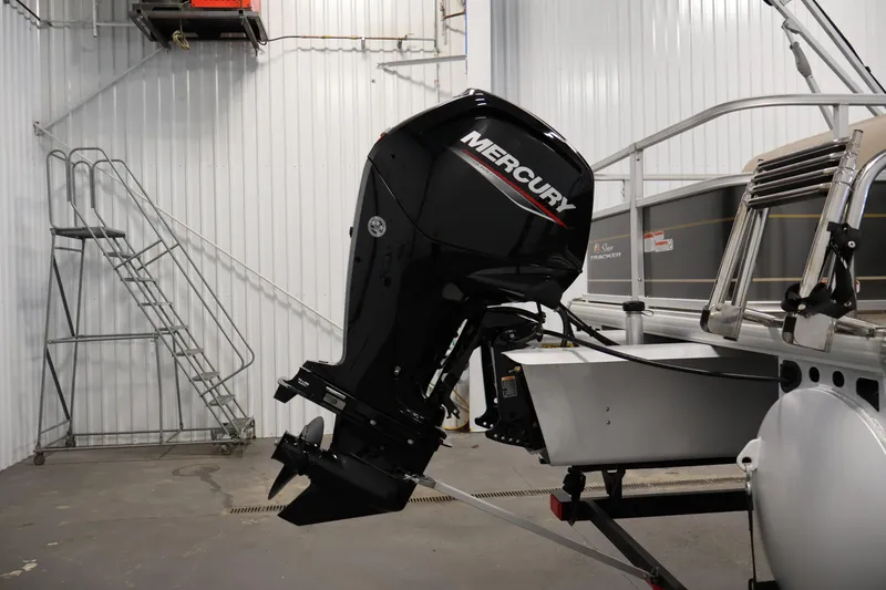 Slide: The Image of 2023 Sun Tracker Party Barge 18 DLX with Mercury outboard motor in a garage. - 36