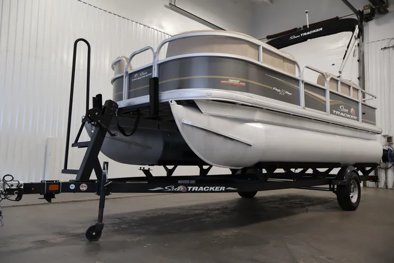 Slide: The Image of 2023 Sun Tracker Party Barge 18 DLX pontoon boat on trailer in indoor setting. - 40