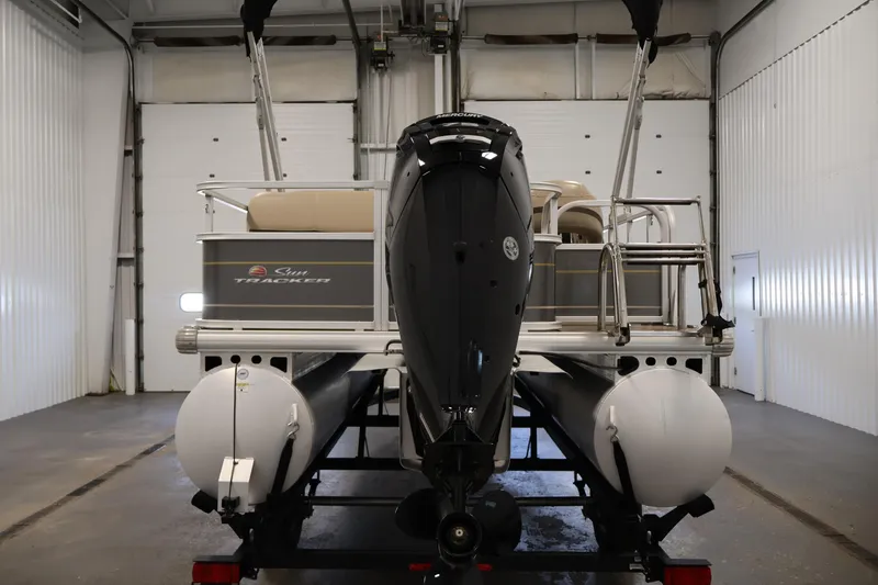 Slide: The Image of 2023 Sun Tracker Party Barge 18 DLX pontoon boat in a garage setting. - 6