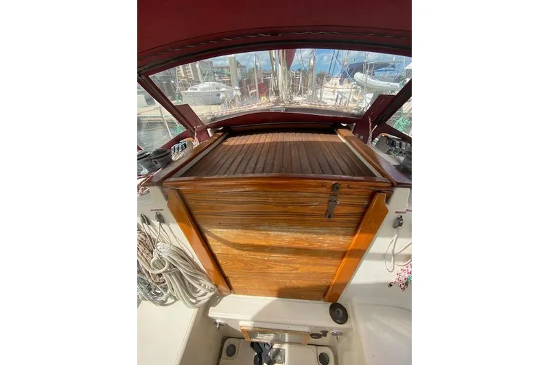 Slide: The Image of 1995 Pacific Seacraft Crealock 34 sailboat cockpit with wooden hatch and marina view. - 11