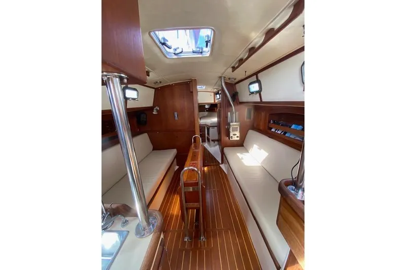 Slide: The Image of Interior of 1995 Pacific Seacraft Crealock 34 sailboat, featuring wood finishes and seating. - 12