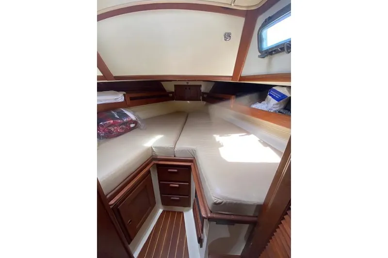 Slide: The Image of 1995 Pacific Seacraft Crealock 34 cabin interior with cozy V-berth and wooden cabinetry. - 13