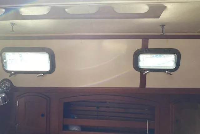 Slide: The Image of Interior of 1995 Pacific Seacraft Crealock 34 sailboat with wooden cabinetry and portholes. - 17