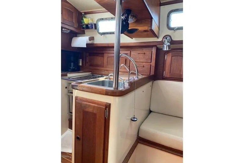 Slide: The Image of Interior of 1995 Pacific Seacraft Crealock 34 sailboat, featuring wooden cabinetry and compact kitchen. - 18