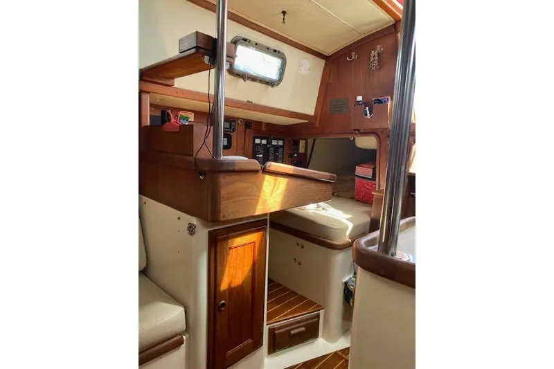 Slide: The Image of Interior of 1995 Pacific Seacraft Crealock 34 sailboat, featuring wood finishes and cozy seating. - 19