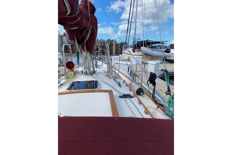Slide: The Image of 1995 Pacific Seacraft Crealock 34 sailboat docked, featuring deck and rigging under blue sky. - 37