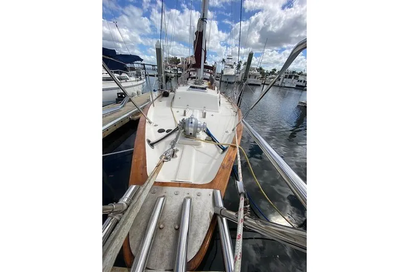 Slide: The Image of 1995 Pacific Seacraft Crealock 34 sailboat docked at marina under cloudy sky. - 4
