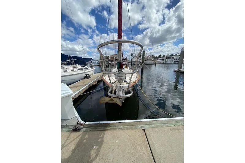 Slide: The Image of 1995 Pacific Seacraft Crealock 34 sailboat docked at marina under cloudy sky. - 5