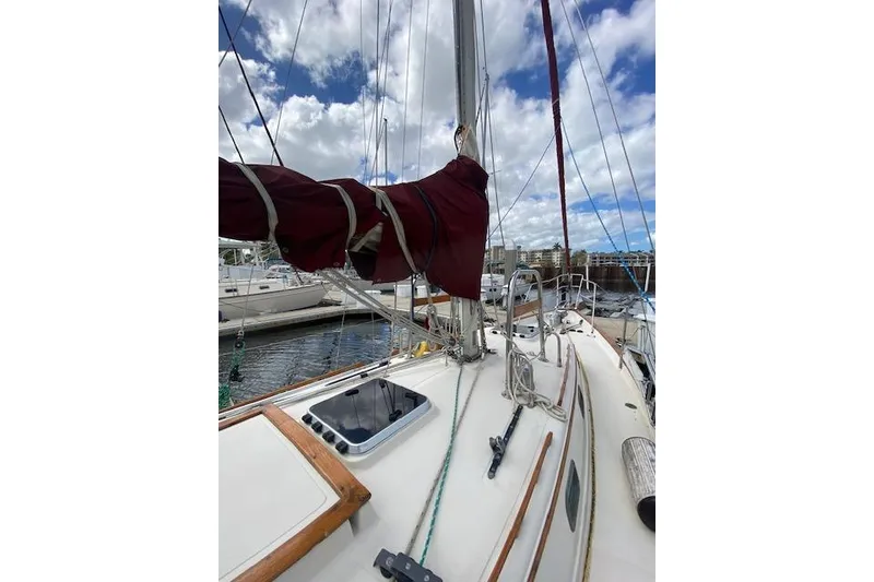 Slide: The Image of Sailboat deck view of 1995 Pacific Seacraft Crealock 34 with rigging and cloudy sky. - 6