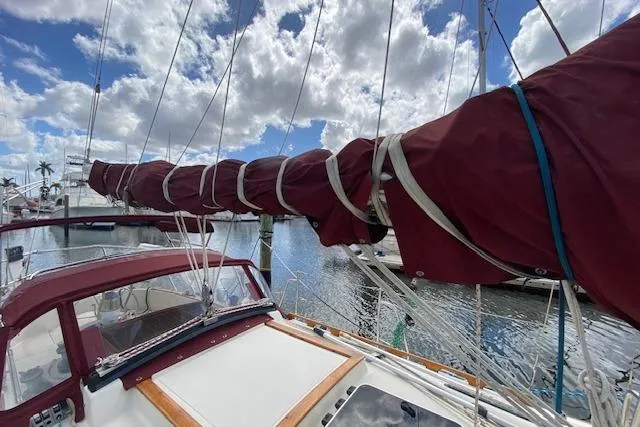 Slide: The Image of Sailboat Pacific Seacraft Crealock 34, 1995 model, docked with sails wrapped, under a cloudy sky. - 7