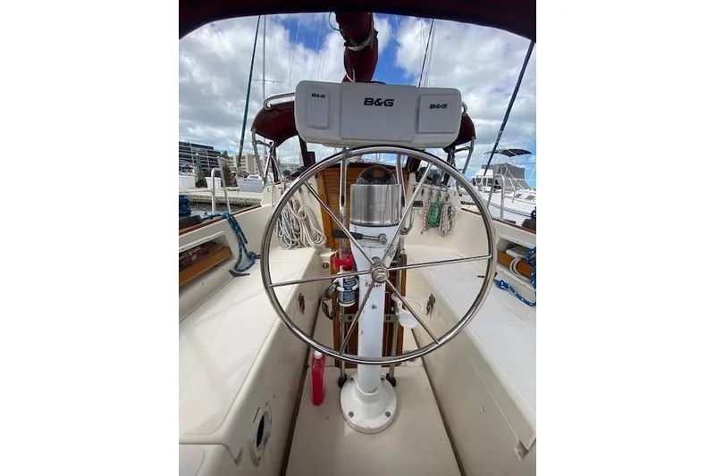Slide: The Image of 1995 Pacific Seacraft Crealock 34 sailboat cockpit with steering wheel and navigation equipment. - 9