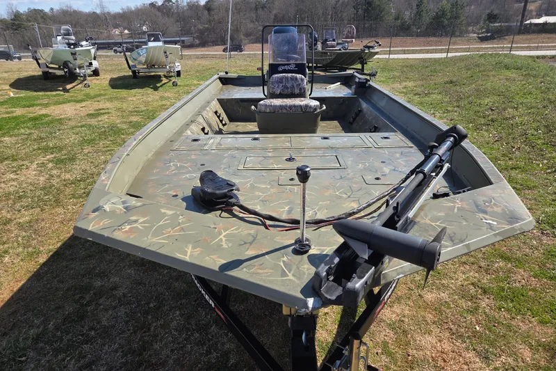Slide: The Image of 2022 Tracker Grizzly 2072 CC boat with camouflage design on grassy field. - 2