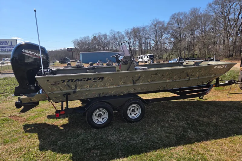 Slide: The Image of 2022 Tracker Grizzly 2072 CC boat on trailer, camo design, parked outdoors. - 4