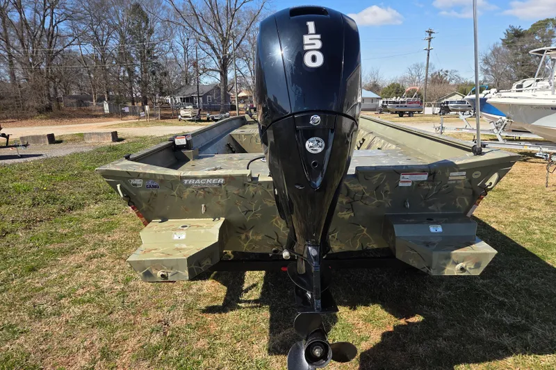 Slide: The Image of 2022 Tracker Grizzly 2072 CC boat with 150 HP outboard motor, parked on grass. - 6