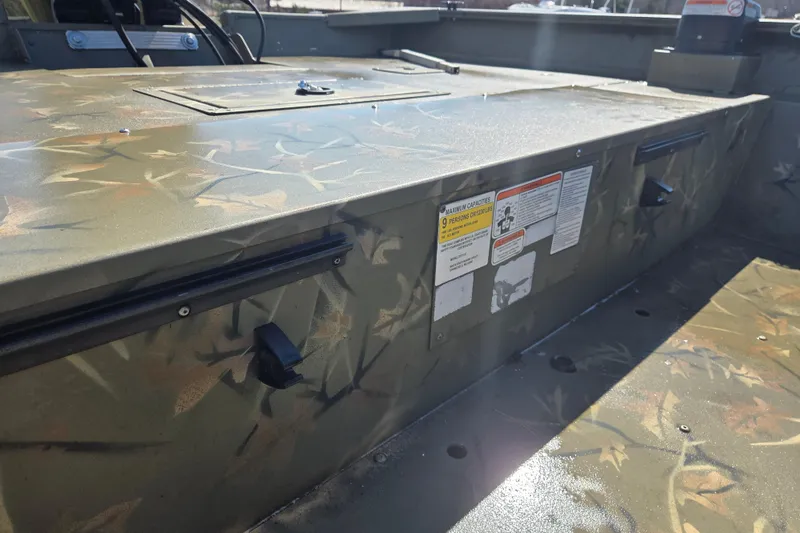 Slide: The Image of 2022 Tracker Grizzly 2072 CC boat interior with camouflage design and safety labels. - 7