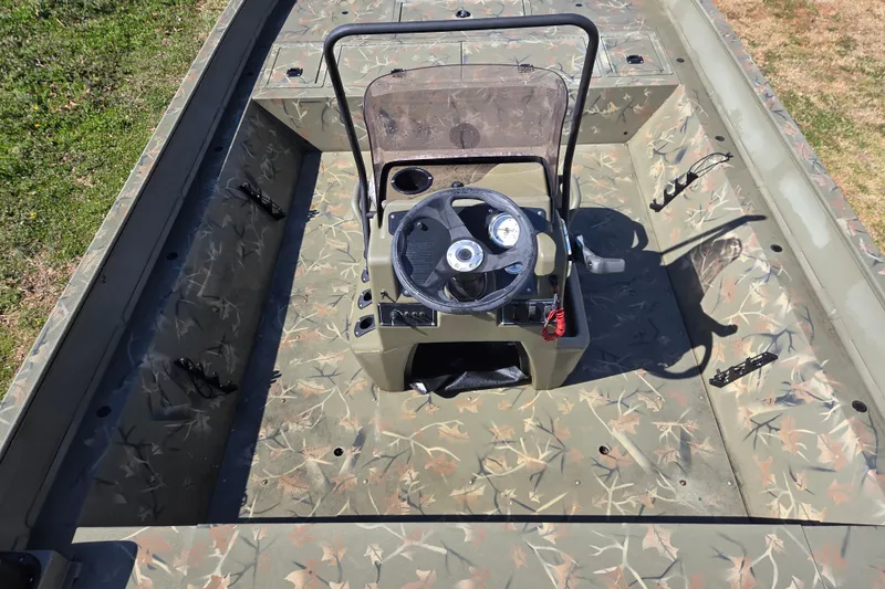 Slide: The Image of 2022 Tracker Grizzly 2072 CC boat interior with camouflage design and central steering console. - 8