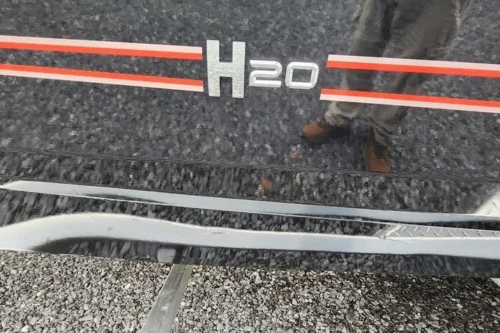 Slide: The Image of 2025 Xpress H20 Bass boat with red stripes on a textured black surface. - 17