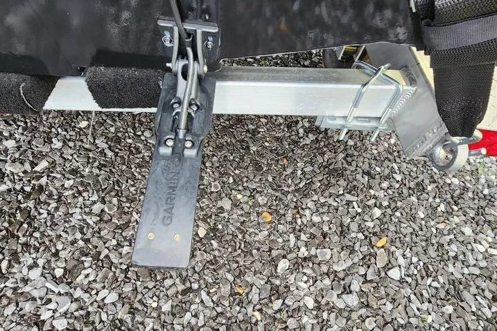 Slide: The Image of Trailer hitch and mount of 2025 Xpress H20 Bass boat on gravel surface. - 4